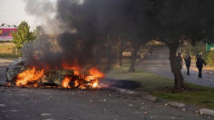 Une voiture de police incendiée après une manifestation d'Israëliens arabes à Lod (Israël),&nbsp;mardi 11 mai 2021. (- / AFP)