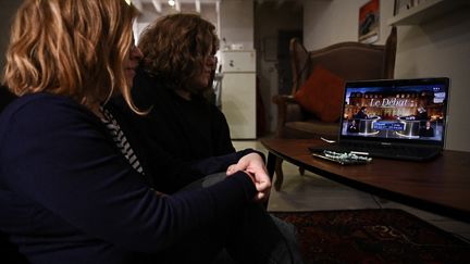 Deux femmes regardent à Bordeaux le débat de l'entre-deux-tours de la présidentielle 2022 entre Marine Le Pen et Emmanuel Macron, le 21 avril 2022. (PHILIPPE LOPEZ / AFP)