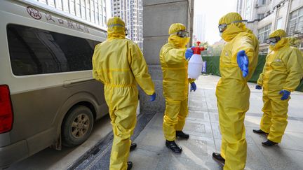 Du personnel d'un salon funéraire se désinfecte après avoir transféré un corps dans un hôpital, à la suite de l'épidémie du nouveau coronavirus à Wuhan, en Chine, le 30 janvier 2020.  (CHINA DAILY CDIC / REUTERS)