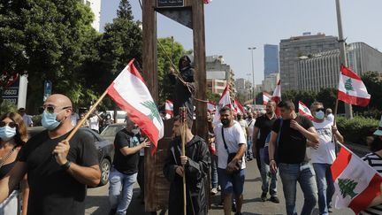 Des manifestants défilent à Beyrouth avec une guillotine pour dénoncer la corruption des dirigeants du Liban, le 4 août 2021, un an après les explosions qui ont dévasté une partie de la capitale. (JOSEPH EID / AFP)