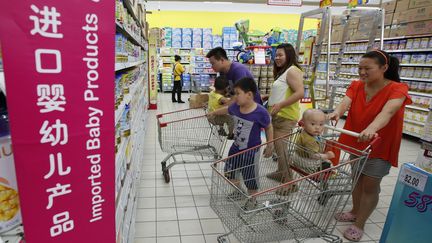 Une famille chinoise devant un rayon de lait infantile import&eacute; &agrave; P&eacute;kin (Chine), le 3 juillet 2013. (KIM KYUNG HOON / REUTERS)