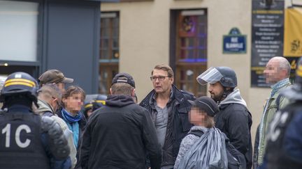 Philippe Mizerski, major à la direction de l’ordre public et de la circulation (DPOC) tient un briefing avec son équipe de police et Alexandre Benalla, le 1er-Mai 2018, place de la Contrescarpe, à Paris.&nbsp; (AFP)