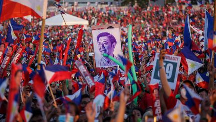 Des soutiens de Ferdinand Marcos Junior, vainqueur de l'élection présidentielle aux Philippines, brandissent un portrait de leur candidat, le 7 mai 2022. (JAM STA ROSA / AFP)