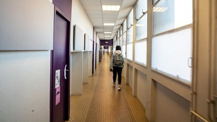 Un élève marche dans un couloir du collège François-Villon, à Paris, le 14 janvier 2022. (ALINE MORCILLO / HANS LUCAS / AFP)