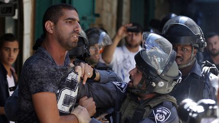 Des policiers isra&eacute;liens tentent de ma&icirc;trisier un Palestien &agrave; J&eacute;rusalem-Est, le 28 septembre 2015. (AHMAD GHARABLI / AFP)