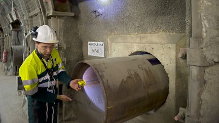 Un employ&eacute; montre une alv&eacute;ole dans laquelle doivent &ecirc;tre stock&eacute;s des d&eacute;chets radioactifs, sur le site du laboratoire souterrain de l'Andra, &agrave; Bure (Meuse), le 28 juin 2011.&nbsp; (JEAN-CHRISTOPHE VERHAEGEN / AFP)