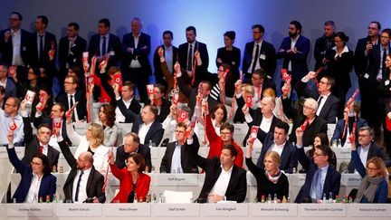 Des membres du parti social-démocrate allemand (SPD) votent sur la poursuite des négociations pour la formation d'une coalition gouvernementale avec Angela Merkel, lors d'un congrès du parti à Bonn (Allemagne), le 21 janvier 2018.&nbsp; (THILO SCHMUELGEN / REUTERS)