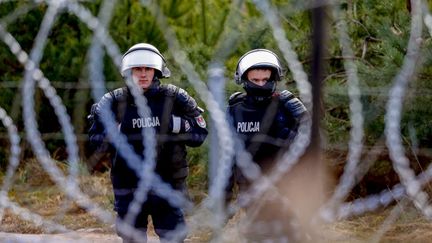 Des policiers polonais qui gardent la frontière entre la Pologne et la Biélorussie, le 23 novembre 2021. (SEFA KARACAN / ANADOLU AGENCY / AFP)