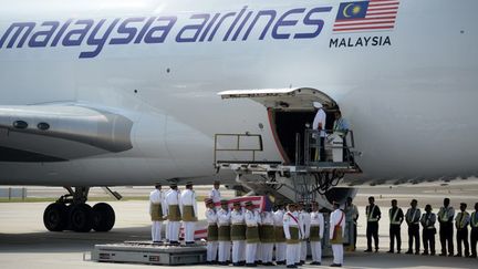 Des soldats portent les cercueils des victimes malaisiennes du crash du vol MH17,&nbsp;le 22 ao&ucirc;t 2014, &agrave; l'a&eacute;roport de Kuala Lumpur (Malaisie). (MANAN VATSYAYANA / AFP)