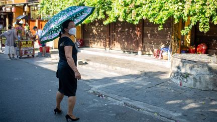 Une passante à Hoi An (Vietnam) lors d'une vague de chaleur, le 14 mai 2022. (CHRIS HUMPHREY / ANADOLU AGENCY / AFP)