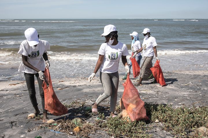 Des bénévoles ramassent les déchets collectés le long de la mangrove de l'aire marine protégée de Joal-Fadiouth, le 2 février 2021.&nbsp; (JOHN WESSELS / AFP)