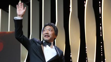 Pour sa sixième venue à Cannes, le cinéaste japonais Hirokazu Kore-eda a été distingué par la Palme d'Or pour "Une affaire de famille", l'histoire d'un couple de marginaux qui recueille des enfants abandonnés.
 (Valery HACHE / AFP)