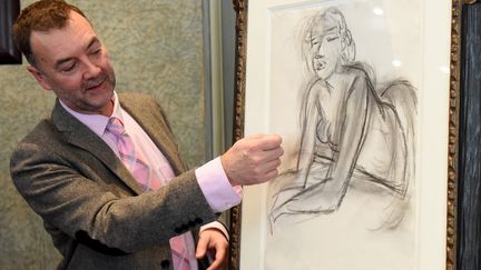 Patrice Deparpe, directeur du Musée Matisse du Cateau-Cambrésis (Nord), presente un dessin d'Henri Matisse, "La femme accoudee",&nbsp;&nbsp;de l'exposition "Devenir Matisse", visible jusqu'au 9 février 2020..&nbsp; (FRANCOIS LO PRESTI / AFP)