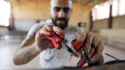 il lui est devenu très difficile de réaliser ses tableaux à l’endroit. Pour pimenter son procédé, il réalise ses toiles à deux mains.
 (Mohamed Abd el-Ghany / Reuters)