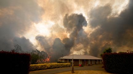 Des arbres brûlent&nbsp;derrière une propriété à Balmoral, à 150 kilomètres au sud-ouest de Sydney, le 19 décembre 2019.&nbsp; (PETER PARKS / AFP)