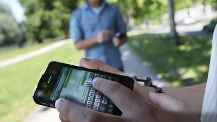 Une personne en train d'envoyer un SMS via son téléphone portable (illustration). (BONNAUD GUILLAUME / MAXPPP)