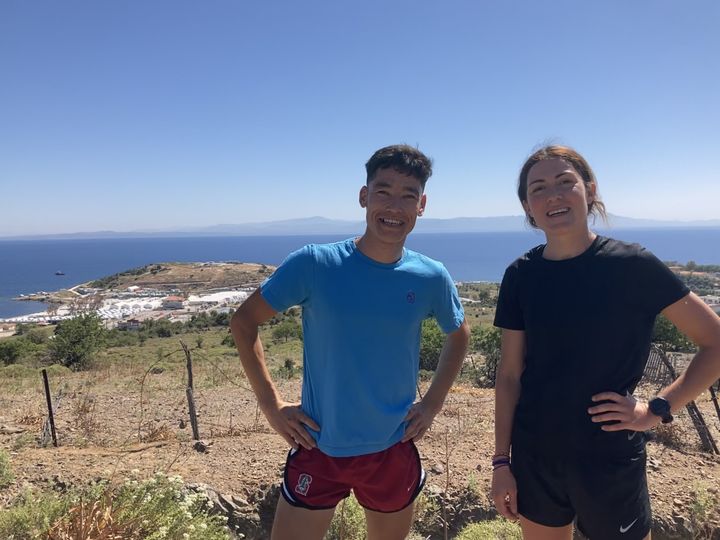 Mahmood Alizada et Estelle Jean, avec&nbsp;derrière eux&nbsp;le camp de Mavrovouni, sur l'île de Lesbos (Grèce), le 22 mai 2022. (Louise Le Borgne)