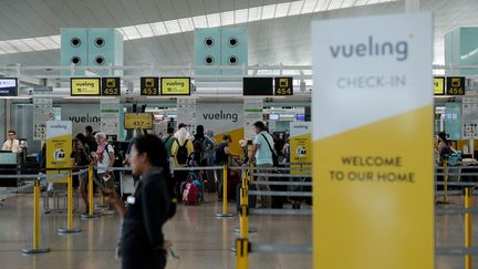 Des passagers de Vueling font la queue pour le check-in à l'aéroport de Barcelone, en juillet 2019. (PAU BARRENA / AFP)