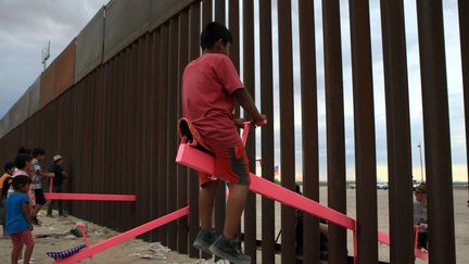 Des enfants mexicains et américains font ensemble de la balançoire, malgré le mur qui sépare leurs deux pays. Cette oeuvre, "The Teeter Totter Wall" a reçu le prix&nbsp;Beazley 2020 du design.&nbsp; (LUIS TORRES / AFP)