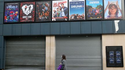 Une passante devant un cinéma de Nancy fermé durant le reconfinement, le 21 décembre 2020. (NICOLAS GUYONNET / HANS LUCAS via AFP)