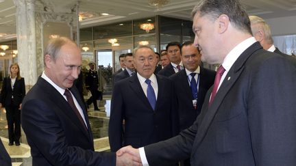 Le pr&eacute;sident Russe Vladimir Poutine et son homologue Ukrainien Petro Porochenko se saluent, &agrave; Minsk (Bi&eacute;olorussie), le 26 ao&ucirc;t 2014. (SERGEI BONDARENKO / REUTERS)