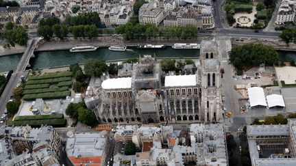 La cathédrale Notre-Dame de Paris couverte d'échafaudages, le 14 juillet 2019, trois mois après l'incendie qui a notamment détruit sa charpente et sa flèche. (PHILIPPE WOJAZER / REUTERS)