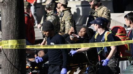 Une femme est transportée sur une civière après des tirs lors de la parade des Kansas City Chiefs, à Kansas City, dans le Missouri (Etats-Unis), le 14 février 2024. (ANDREW CABALLERO-REYNOLDS / AFP)