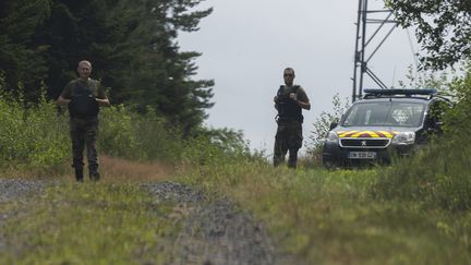 Deux gendarmes forment un barrage dans le cadre de l'affaire Lina, dans la forêt communale d'Anould, le 31 juillet 2024. (THOMAS TOUSSAINT / MAXPPP)