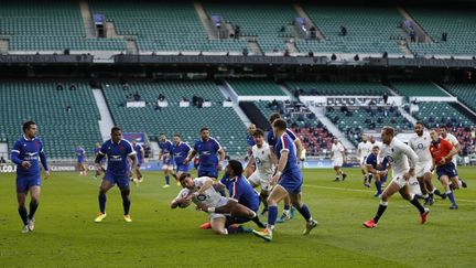 L'Anglais Ben Youngs pris par la solide défense française. (ADRIAN DENNIS / AFP)