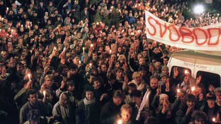 Des étudiants tchécoslovaques tiennent des bougies le 17 novembre 1989 et manifestant leur soutien à l'opposant Vaclav Havel. Réunis dans le quartier d'Albertov à Prague, la capitale de la Tchécoslovaquie, ils demandent plus de démocratie et la fin du régime communiste.  (LUBOMIR KOTEK / AFP)