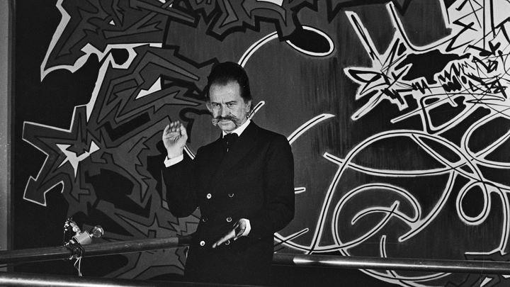 Portrait du peintre Georges Mathieu devant l'un de ses tableaux à la manufacture des Gobelins en 1969. (JOSEE LORENZO / INA)