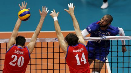 Le Fran&ccedil;ais Earvin N'Gapeth face &agrave; deux joueurs serbes en finale de la Ligue mondiale de volley-ball, &agrave; Rio de Janeiro (Br&eacute;sil), le 19 juillet 2015. (SERGIO MORAES / REUTERS)