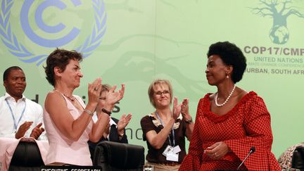 La ministre des Affaires &eacute;trang&egrave;res sud-africaine et pr&eacute;sidente de la conf&eacute;rence sur le climat de Durban (droite), re&ccedil;oit une ovation &agrave; l'issue du sommet le 11 d&eacute;cembre 2011. (RAJESH JANTILAL / AFP)