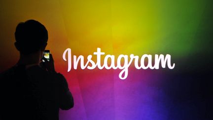 Un employé du réseau social Instagram filme le logo de l'entreprise à Menlo Park, en Californie (Etats-Unis), le 20 juin 2013. (JOSH EDELSON / AFP)