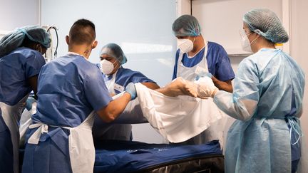 Des soignants portent un patient atteint du Covid-19 placé sous assistance respiratoire dans une chambre de l'unité de soins intensifs du Centre hospitalier universitaire de Pointe-à-Pitre (Guadeloupe), le 3 septembre 2021. (CARLA BERNHARDT / AFP)