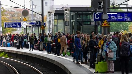 Des passagers attendent le train à Berlin (Allemagne), le 8 octobre 2022, alors que le trafic ferroviaire est paralysé. (JOHN MACDOUGALL / AFP)