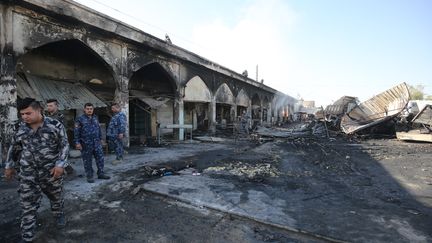 Des policiers irakiens inspectent la scène de l'attaque, le 8 juillet 2016, à&nbsp;Balad au nord de Bagdad. (AHMAD AL-RUBAYE / AFP)