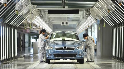 Des employ&eacute;s sur une cha&icirc;ne de montage d'une usine de PSA Peugeot Citro&euml;n, le 2 juillet 2013 &agrave; Wuhan (Chine). ( AFP )