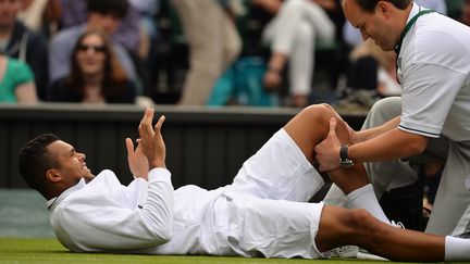 Jo-Wilfried Tsonga se fait masser le genou, le 26 juin 2013 &agrave; Wimbledon (Royaume-Uni). (CARL COURT / AFP)