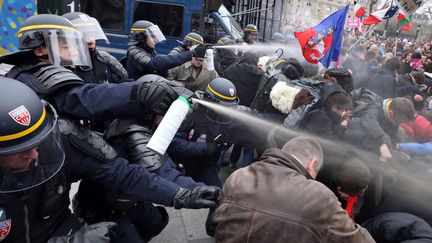 Des CRS aspergent de gaz lacrymog&egrave;ne des manifestants anti mariage pour tous sur l'avenue des Champs-Elys&eacute;es &agrave; Paris, le 24 mars 2013. (THOMAS SAMSON / AFP)