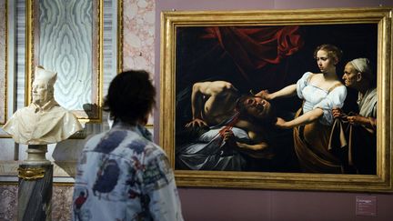 Une femme observe les toiles du Caravage&nbsp;accroch&eacute;es lors d'une exposition organis&eacute;e &agrave; Rome (Italie), en 2009-2010. (VINCENZO PINTO / AFP)