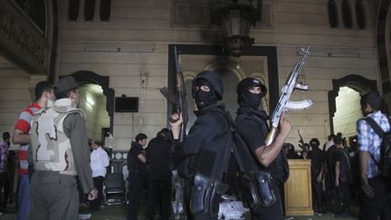 Des policiers &eacute;gyptiens &agrave; l'int&eacute;rieur de la mosqu&eacute;e al-fath o&ugrave; sont retranch&eacute;s des partisans des Fr&egrave;res musulmans au Caire.&nbsp; (MUHAMMAD HAMED / REUTERS)