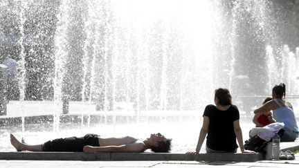 Des gens se rafra&icirc;chissent pr&egrave;s d'une fontaine &agrave; Strasbourg, le 18 juin 2013. ( MAXPPP)