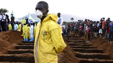 Des hommes attendent l'enterrement de victimes d'inondations au cimetière de Waterloo, près de Freetown (Sierra Leone), le 17 août 2017.&nbsp; (SEYLLOU / AFP)