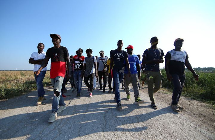 Marche d'ouvriers agricoles, africains pour la plupart, le 8 août 2018 près de Foggia (Italie) après la mort de 16 de leurs collègues dans deux accidents de la route distincts (REUTERS/Alessandro Bianchi)