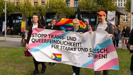 Des manifestants allemands brandissent la banderole "Arrêtez les hostilités contre les personnes trans et queer", lors d'une mobilisation à Dusseldorf (Allemagne), le 17 septembre 2022. (YING TANG / NURPHOTO / AFP)