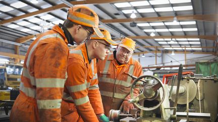 Un ing&eacute;nieur enseigne son m&eacute;tier &agrave; des apprentis dans une usine de Doncaster (Royaume-Uni). (MONTY RAKUSEN / GETTY IMAGES / CULTURA RF)