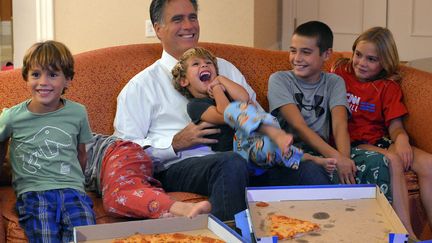 Le candidat r&eacute;publicain Mitt Romnet regarde &agrave; la t&eacute;l&eacute;vision la retransmission de la convention de son parti avec ses petits-enfants depuis sa chambre d'h&ocirc;tel &agrave; Tampa (Floride), le 29 ao&ucirc;t 2012. (JEWEL SAMAD / AFP)