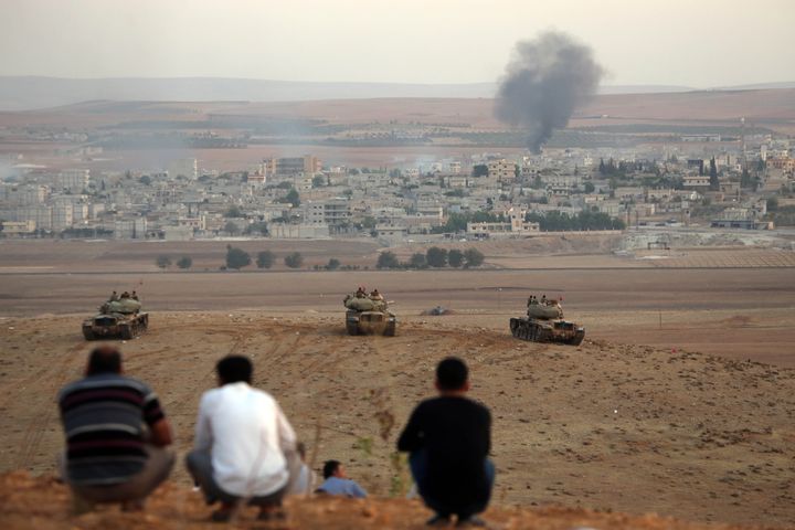 Des r&eacute;fugi&eacute;s kurdes observent les combats &agrave; Kobani depuis la Turquie, le 9 octobre 2014 &agrave; Suruc (Turquie). (IBRAHIM ERIKAN / ANADOLU AGENCY / AFP)