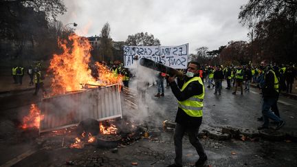 Les "gilets jaunes" à côté d'une barricade à Paris, le 1er décembre 2018. (ABDULMONAM EASSA / AFP)